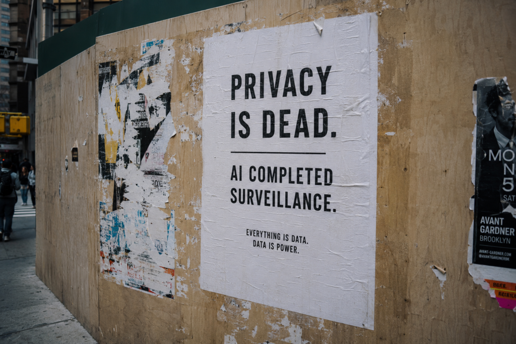 Street poster reading “Privacy is dead. AI completed surveillance.”